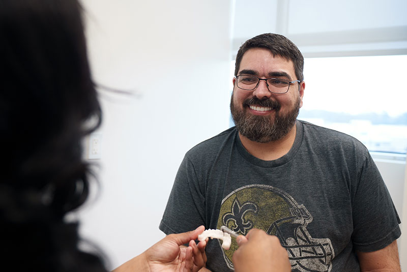 Patient looking at dental implant model